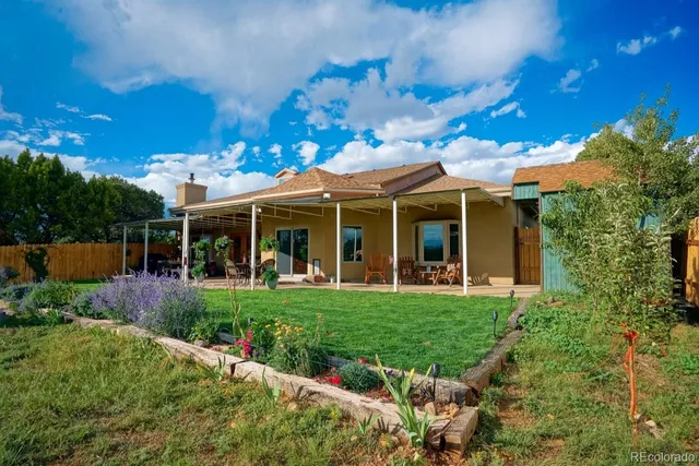 a view of a white house with a big yard and potted plants