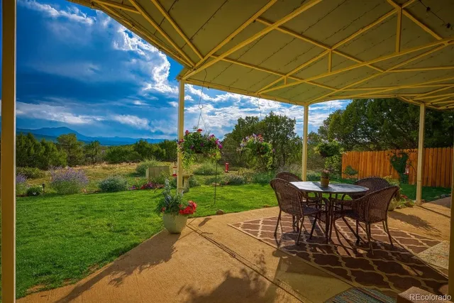 a view of a backyard with table and chairs under an umbrella