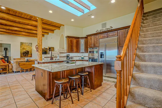 a kitchen with granite countertop a sink and a refrigerator