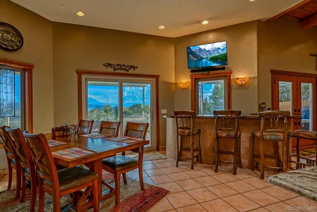 a dining room with furniture and a floor to ceiling window