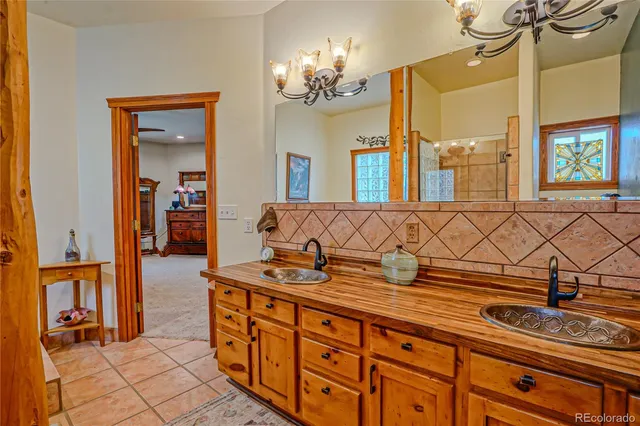 a spacious bathroom with a granite countertop sink a large mirror and a shower