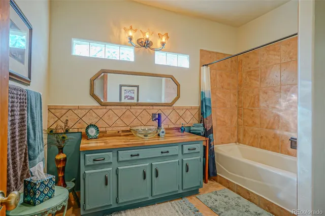 a bathroom with a tub sink and mirror