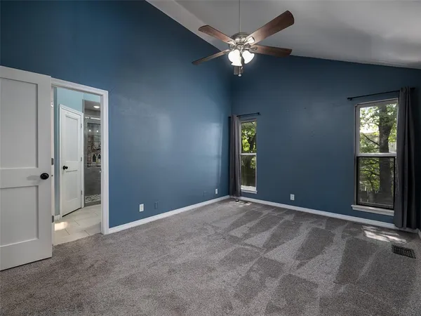 an empty room with chandelier fan