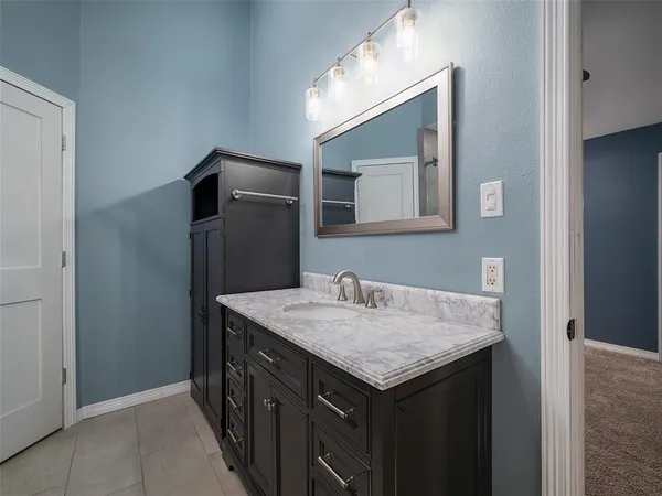 a bathroom with a granite countertop sink and mirror