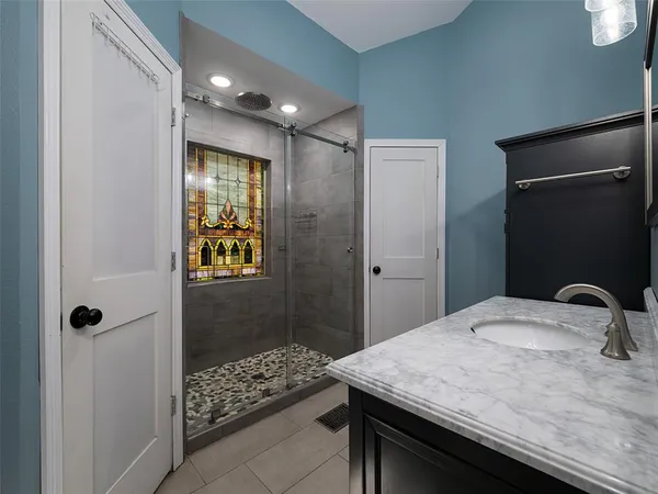 a bathroom with a granite countertop sink a shower and a mirror