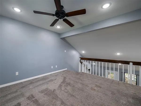 an empty room with ceiling fan and window