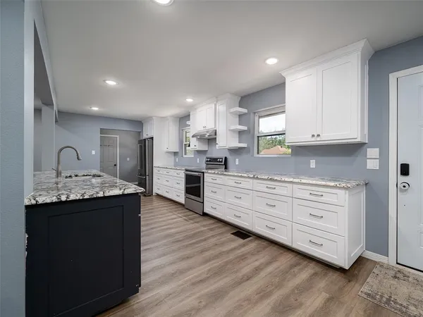a kitchen with stainless steel appliances granite countertop a sink stove and refrigerator