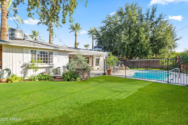 a view of a house with a yard and a tree