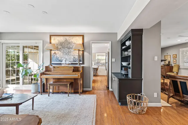 a living room with furniture a table and large windows
