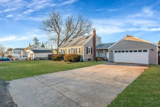 a view of a white house with a big yard and large trees