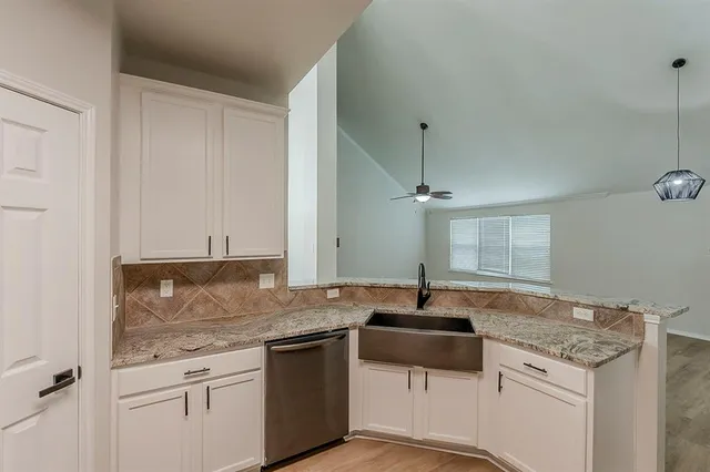 a kitchen with granite countertop a sink and cabinets