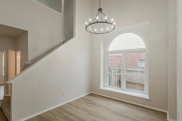 a view of empty room with window and wooden floor