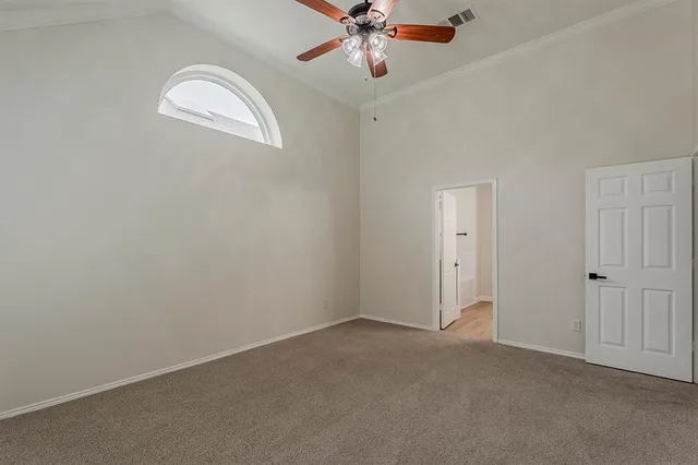an empty room with a chandelier fan