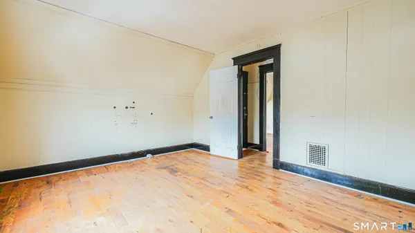 a view of empty room with wooden floor