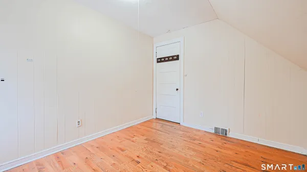 a view of empty room with wooden floor