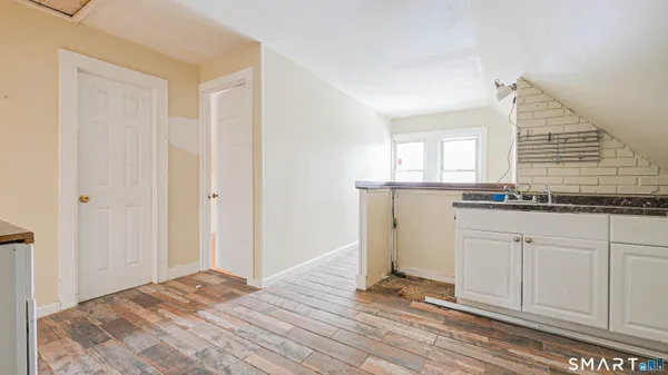 a view of a kitchen with wooden floor and staircase