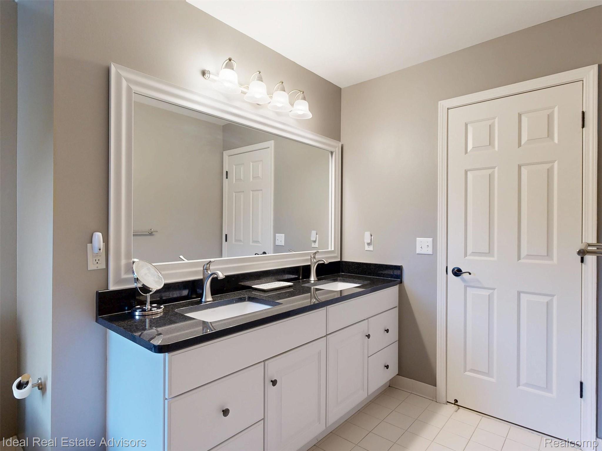 1364 Kentfield Drive Rochester, MI 48307 - Photo 59 of 70 Double vanity with white cabinetry, black countertop, and dual undermount sinks