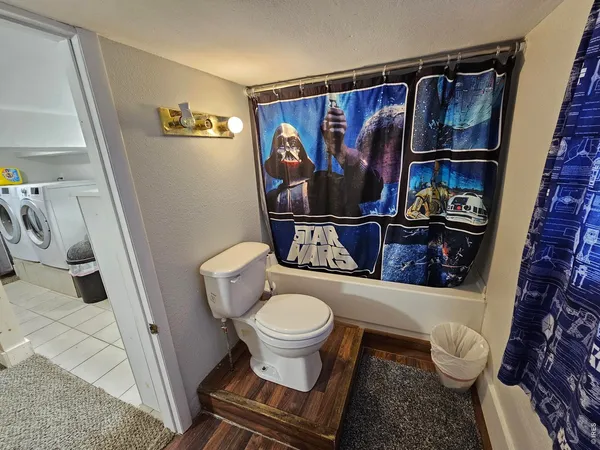 a bathroom with a toilet and a shower curtain
