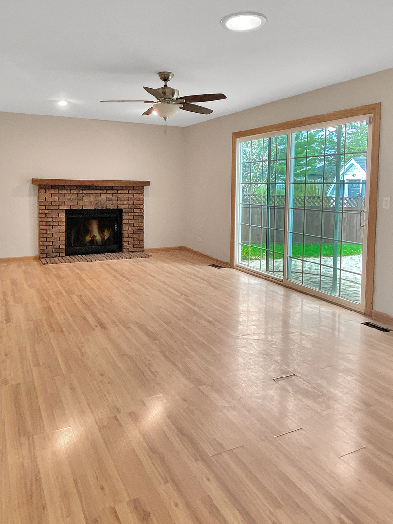 2080 Savannah Road Elgin, IL 60123 - Photo 7 of 17 a view of an empty room with wooden floor fireplace and a window