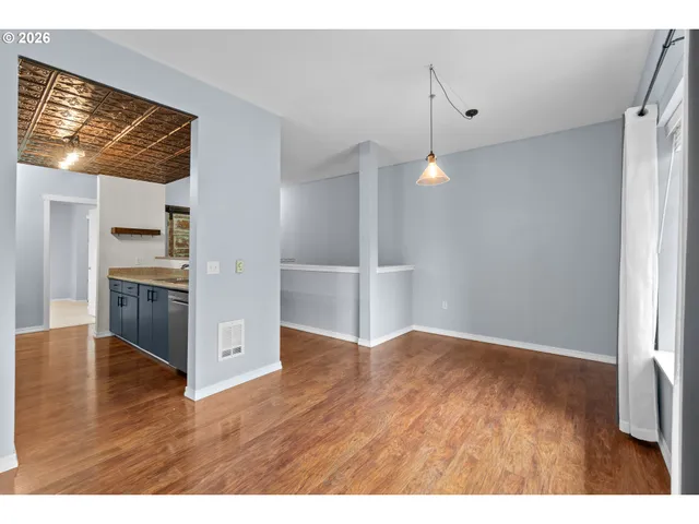 a view of a kitchen with wooden floor electronic appliances and stairs
