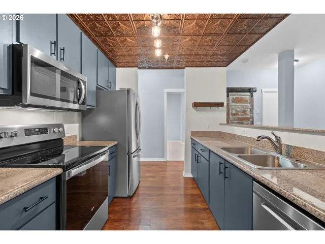 a kitchen with granite countertop stainless steel appliances and wooden cabinets