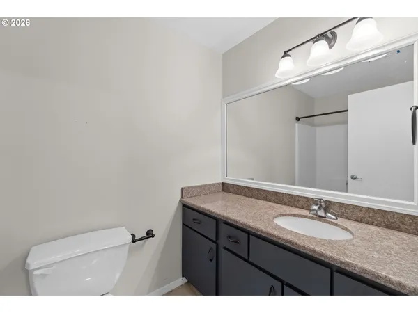 a bathroom with a granite countertop sink a toilet and a mirror