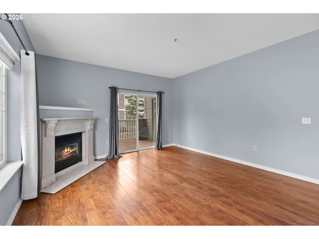 a view of an empty room with a fireplace and a window