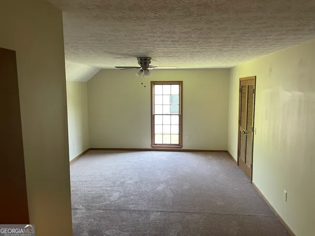 an empty room with windows and closet