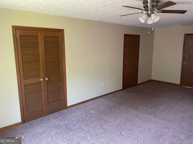 a view of an empty room with a ceiling fan