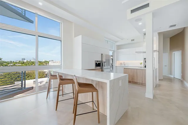 a kitchen with a table chairs refrigerator and cabinets