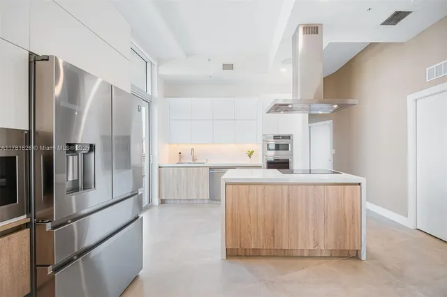 a kitchen with a refrigerator a sink and cabinets
