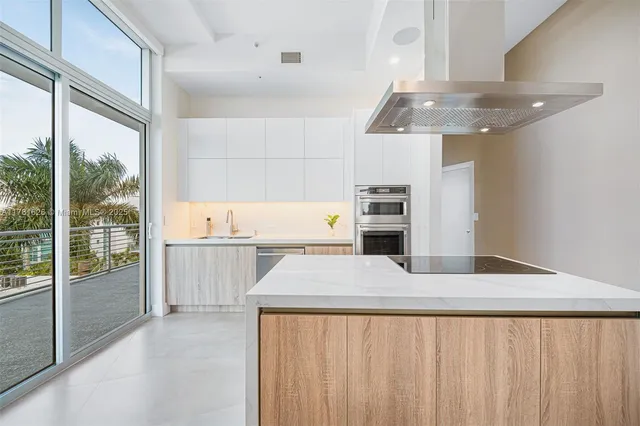a kitchen with a refrigerator and white cabinets