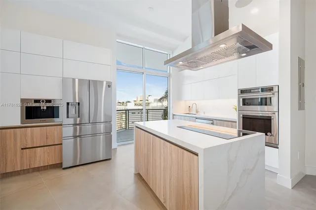 a kitchen with stainless steel appliances granite countertop a refrigerator and a stove top oven