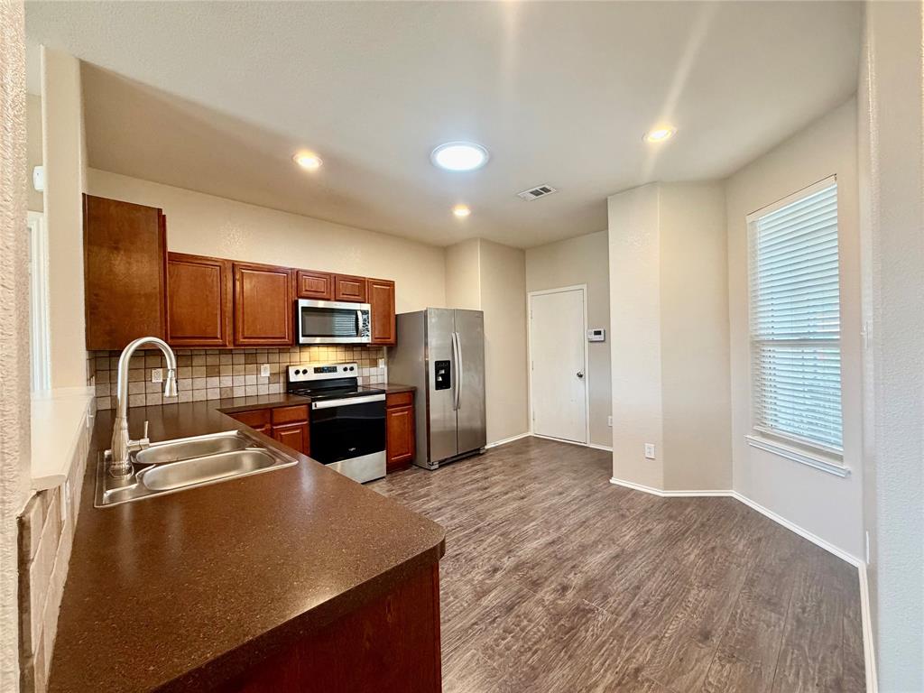5817 Deck House Road Fort Worth, TX 76179 - Photo 5 of 19 Kitchen featuring wood-finish flooring, recessed lighting, and a skylight