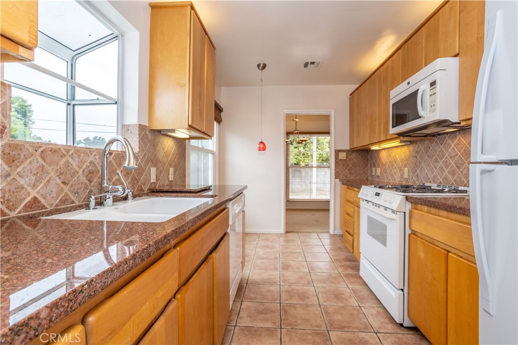 8129 Darby Place Reseda, CA 91335 - Photo 2 of 19 a kitchen with stainless steel appliances granite countertop a sink and a stove next to a window