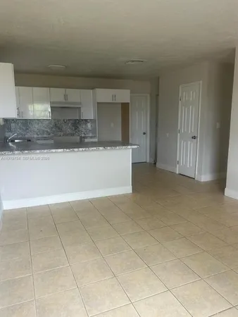 a view of kitchen with stainless steel appliances granite countertop a sink and cabinets