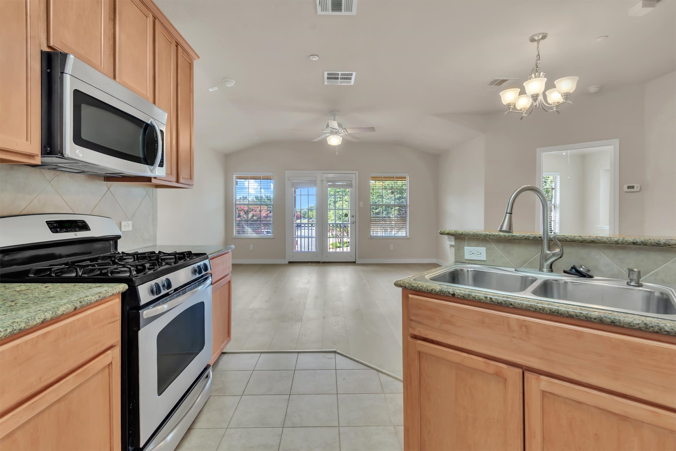 14815 Avery Ranch Boulevard, Unit 2A Austin, TX 78717 - Photo 3 of 27 A well-appointed kitchen flows into a living space with abundant natural illumination and vaulted ceilings.