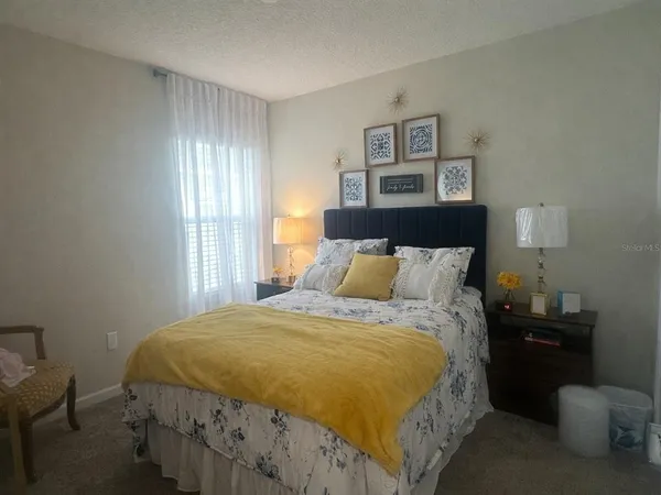 a bed sitting in a bedroom next to a window with lamp