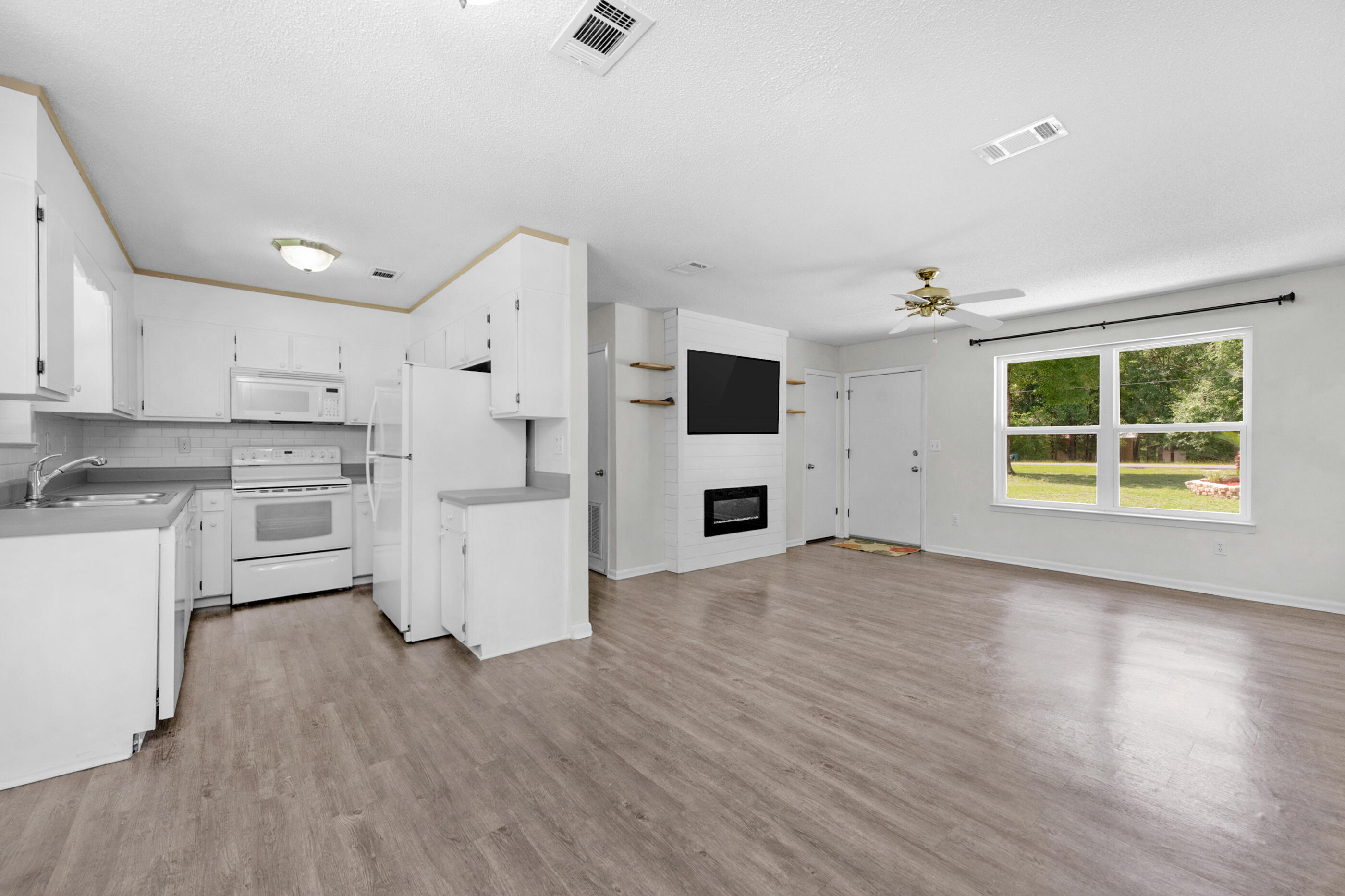 2909 Aplin Road Crestview, FL 32539 - Photo 11 of 29 a view of open kitchen with wooden floor and electronic appliances
