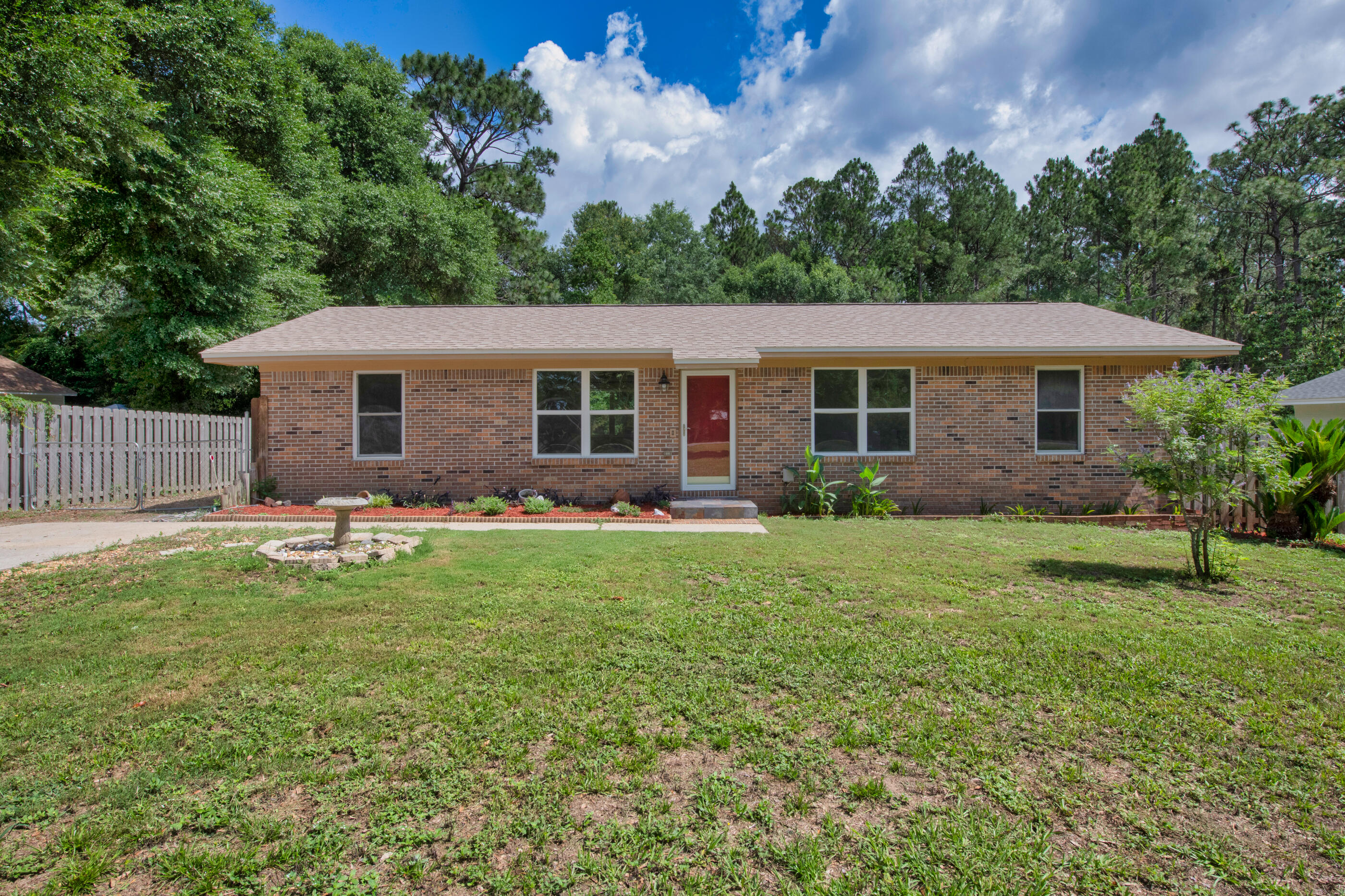 2909 Aplin Road Crestview, FL 32539 - Photo 3 of 29 a backyard of a house with table and chairs plants and large tree