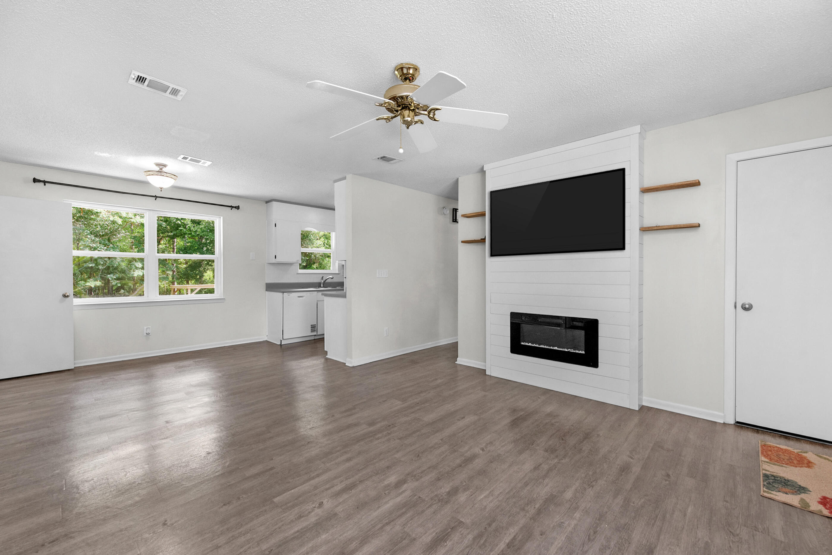 2909 Aplin Road Crestview, FL 32539 - Photo 6 of 29 an empty room with windows fireplace and cabinet