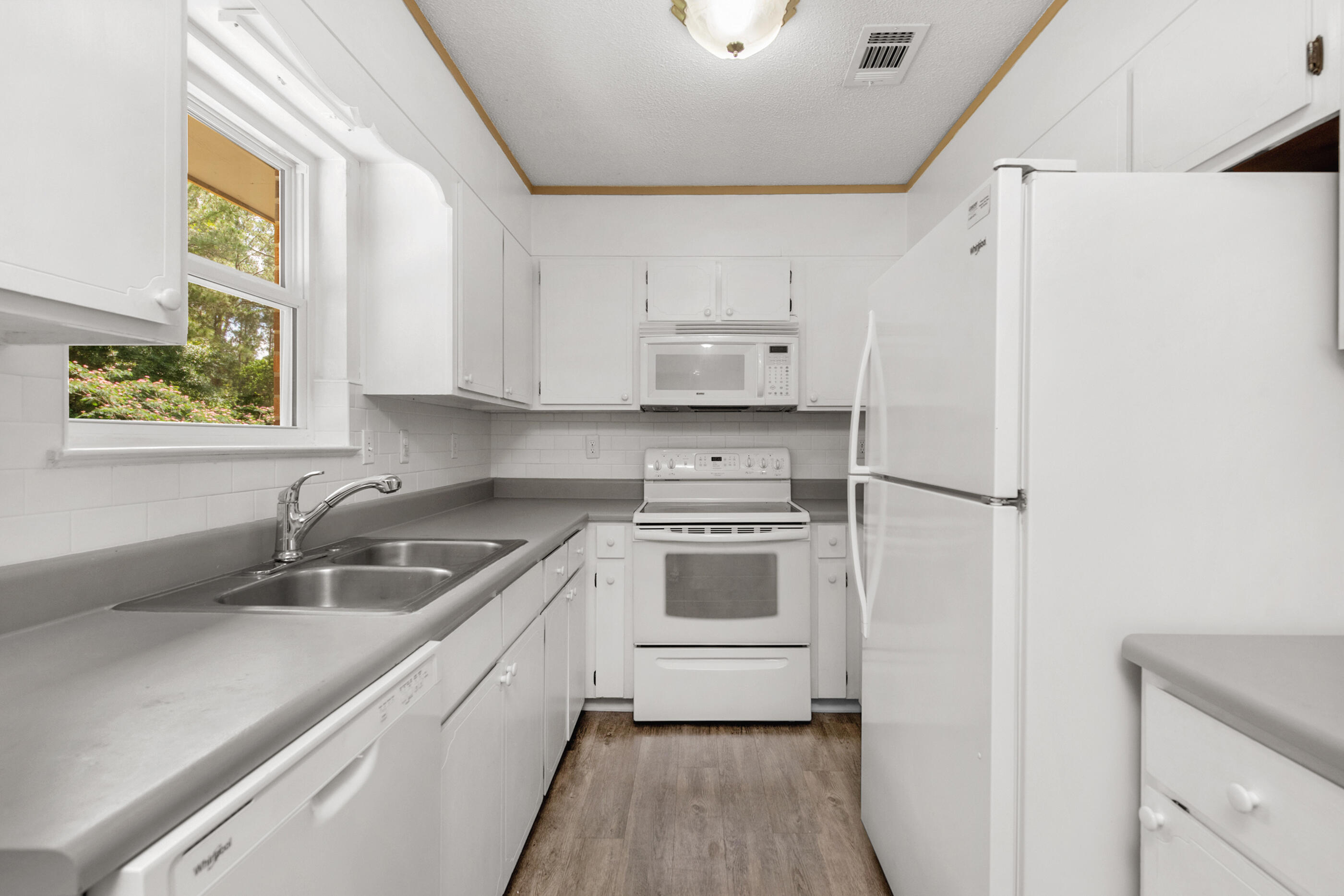 2909 Aplin Road Crestview, FL 32539 - Photo 9 of 29 a kitchen with a sink a refrigerator and window