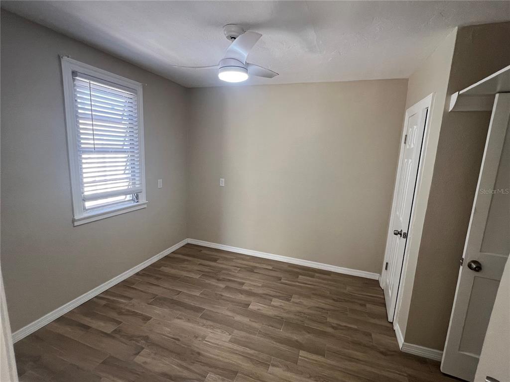116 145th Avenue Madeira Beach, FL 33708 - Photo 9 of 17 an empty room with wooden floor and window