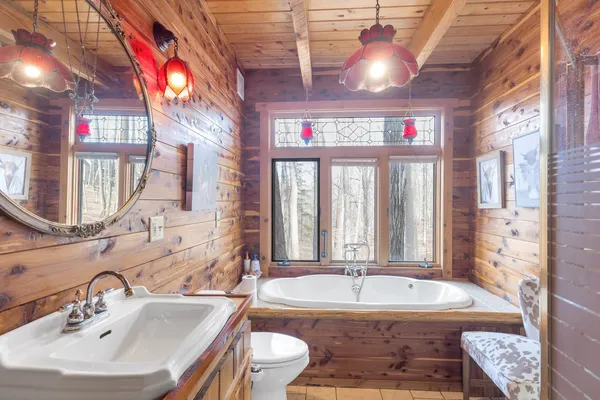 a bathroom with a granite countertop tub and a sink