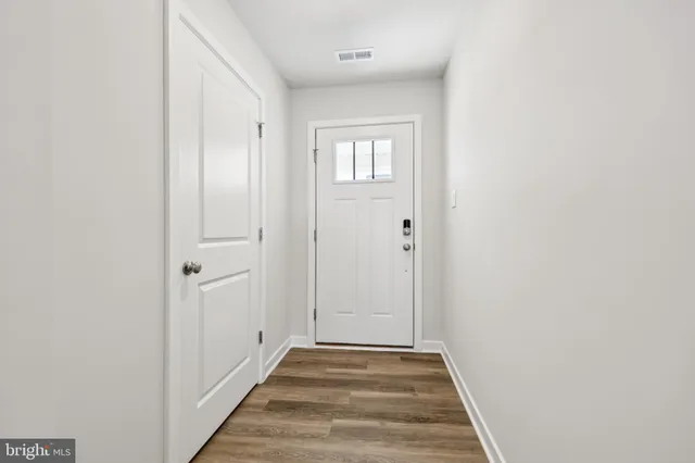 a view of a hallway with wooden floor