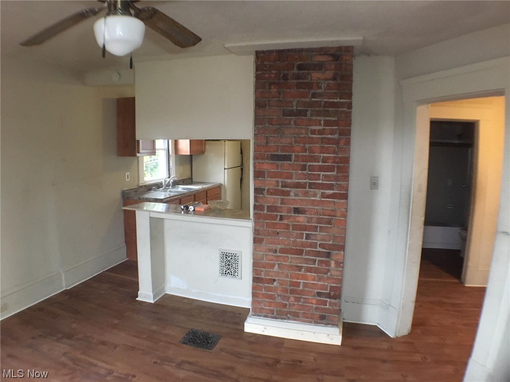 4016 Riverside Avenue Cleveland, OH 44109 - Photo 17 of 25 Kitchen with dark hardwood / wood-style flooring, brick wall, white fridge, sink, and ceiling fan