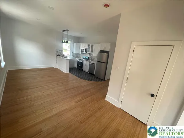 a view of a kitchen with furniture and wooden floor