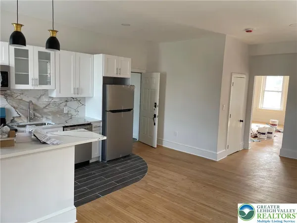 a kitchen with stainless steel appliances granite countertop a refrigerator a stove and a wooden floors