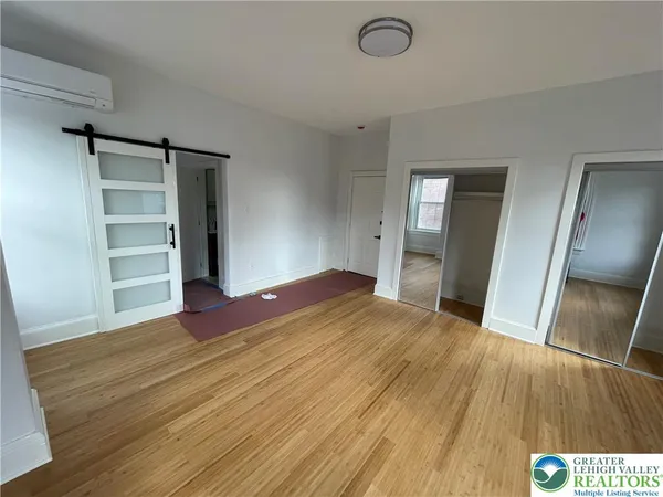 a view of empty room with wooden floor