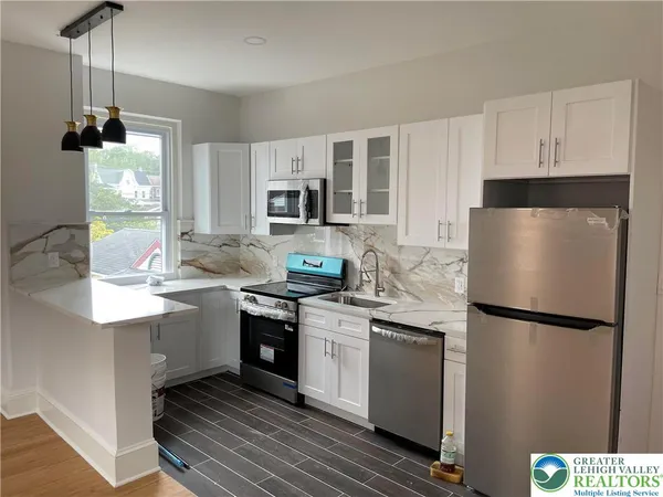 a kitchen with a sink a refrigerator and a stove top oven